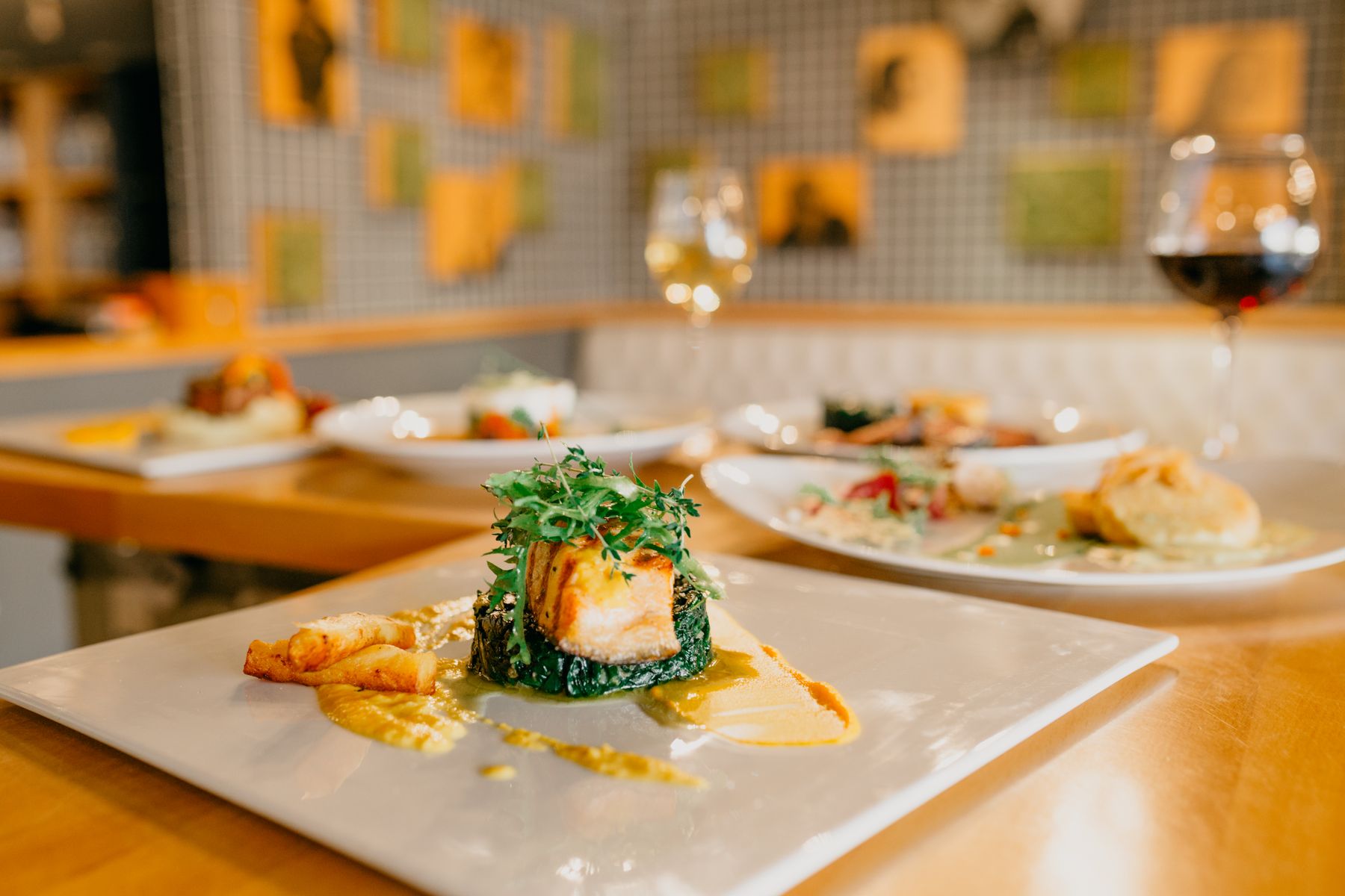 Plates of food and glasses of wine on a restaurant table